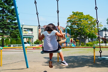 ブランコに乗って遊んでいる小学3年生の女の子