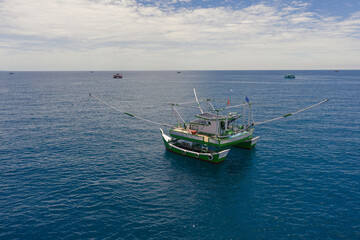 Fototapeta premium Aerial view of a lift net boat that uses nets and lights to catch fish at night