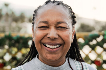 Happy black senior woman smiling looking at camera outdoors. Elderly people, diverse ethnic concept
