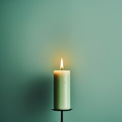 Mint Green background with white thin wax candle with a small lit flame for funeral grief death dead sad emotion with copy space texture for display 
