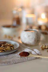 Cup of tea or coffee, cookies, macaroons, chocolate, various nuts and cocoa powder on white background. Selective focus.