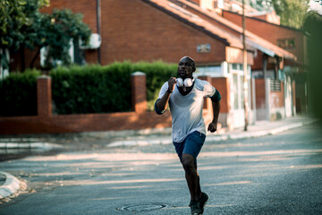 Active young black man jogging on the street
