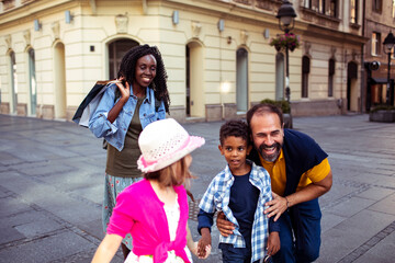 Joyful diverse family having fun on a city walk