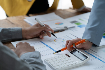 Fototapeta premium close-up hands image, Professional Asian male and female financial consultant or analyst working with them team, brainstorming and analyzing financial data on the report together in the office