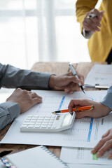 close-up hands image, Professional Asian male and female financial consultant or analyst working with them team, brainstorming and analyzing financial data on the report together in the office