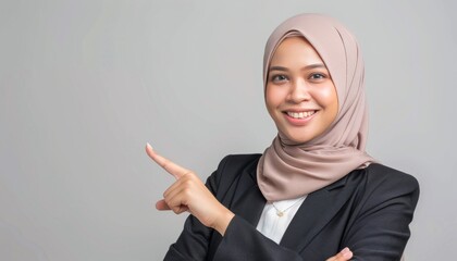 A woman in a hijab pointing directly at the camera, conveying a sense of assertiveness and confidence
