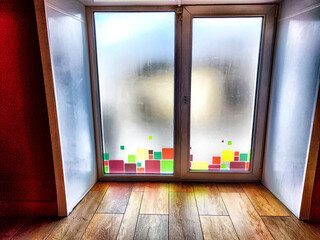 Window and floor. Background, texture. Frosted Glass Door With Colorful Square Details in a Wooden...