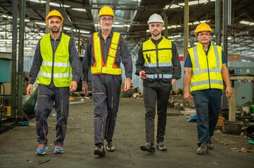 Group of engineer foreman walk line of troops straight in and talk together at end time of work in old Factory. unity teamwork colleague foreman and trainee walk straight in and talk collaboration.