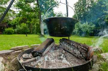 Kociołek z jedzeniem gotowanym na ognisku w ogrodzie