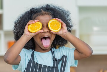 african afro hair black kid Cute ginger hold covering eye with half sliced oranges smile enjoy...