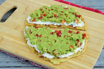 oatmeal breakfast pancakes with mashed avocado, red bell pepper and cream cheese on wooden board