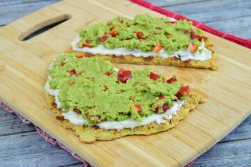 oatmeal breakfast pancakes with mashed avocado, red bell pepper and cream cheese on wooden board