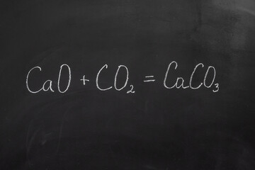 Chemical reaction formula written with chalk on a blackboard