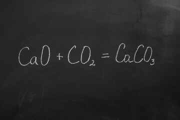 Fototapeta premium Chemical reaction formula written with chalk on a blackboard
