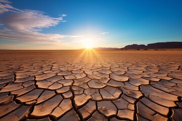 shows a vast desert landscape with cracked earth and a setting sun.