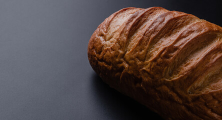 Loaf of bread on a black background. Fresh bakery