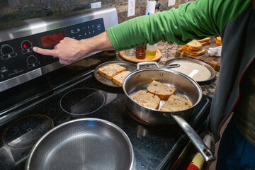 Man cooking french toast at home in his kitchen