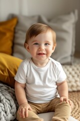 cute boy in a white T-shirt sits on the sofa, looks at the camera and smiles