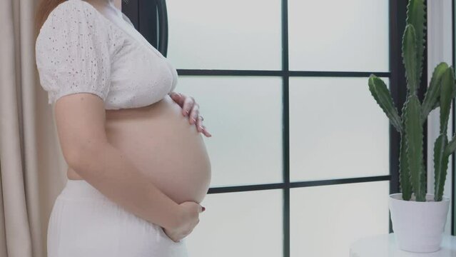 woman holding her belly and holding her belly. Pregnant woman gently holding her bally.
