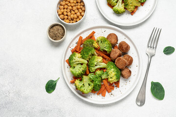 Healthy food broccoli, carrots and vegetable meatballs on a plate top view on a white background with copy space
