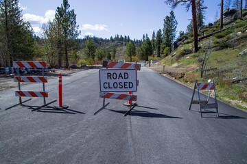 Barricades and signage mark a road closure in the Plumas National Forest due to post Dixie Fire...