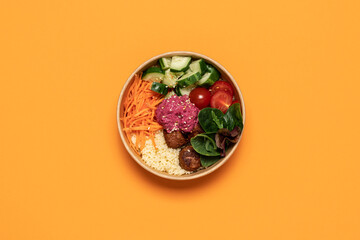 Healthy take away salad with vegan meatballs, vegetables, couscous and beetroot hummus  in...