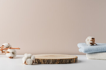 Wooden podium with cotton buds and cotton towels on light background. Presentation of cosmetics, natural product