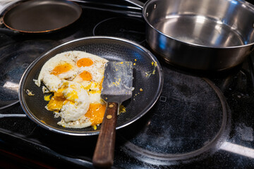 Fried eggs turned to scramble on the cookimng pan