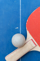 top view pingpong racket and ball on a blue pingpong table at vertical composition