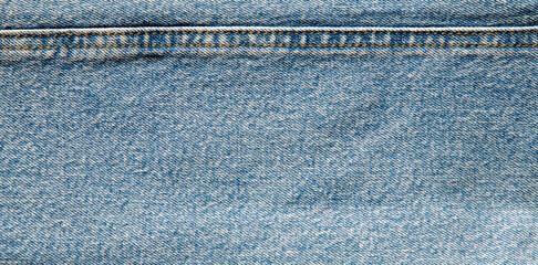 texture of light blue jeans denim fabric with seam background
