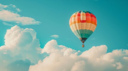 Fototapeta premium A rainbow-colored hot air balloon floating gracefully against a backdrop of fluffy white clouds, creating a picturesque scene in the sky.