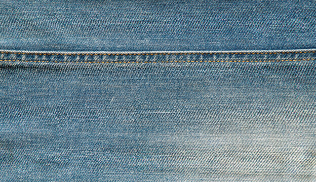 texture of blue jeans denim fabric with seam background