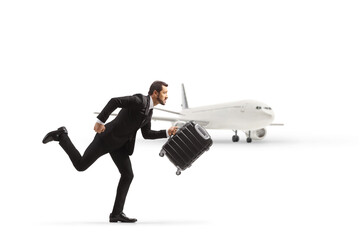 Businessman running and carrying a suitcase near an airplane