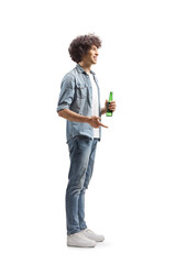 Full length profile shot of a young man with curly hair holding a bottle of beer