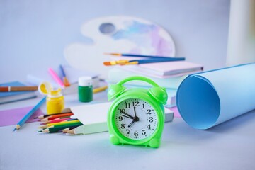 Back to school concept, on the student desk there are stationery, colored pencils, a palette with...