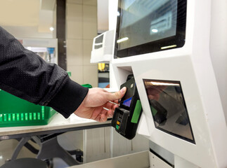Customer pays his purchase at the supermarket,self checkout systems in  retail stores,Barcode scanner,Self checkout machine
