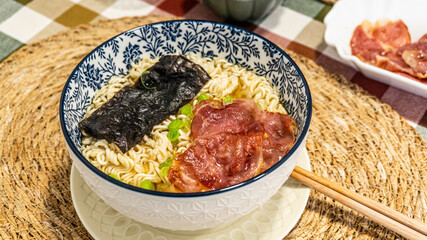Japanese soup with noodles, meat, chives and seaweed