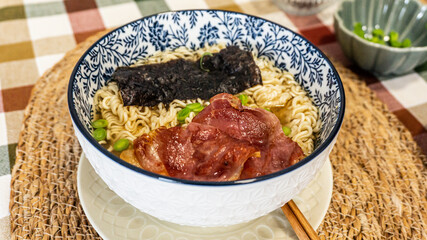 Japanese soup with noodles, meat, chives and seaweed