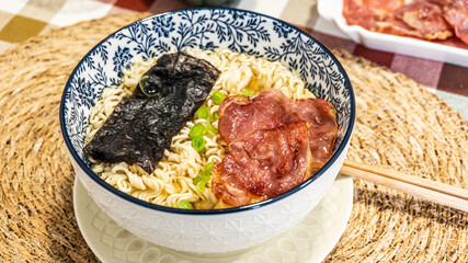 Japanese soup with noodles, meat, chives and seaweed