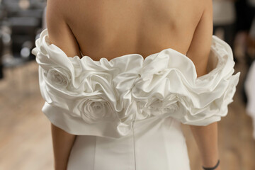 beautiful back of the bride in an original white wedding dress