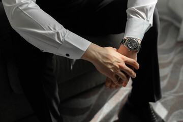 hands of a man in a shirt with a watch