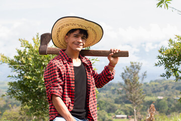 lifestyle: latin lumberjack with straw hat and axe on shoulder