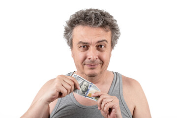 A shaggy gray-haired middle-aged man with stubble wearing a sleeveless T-shirt holds a 100 US...