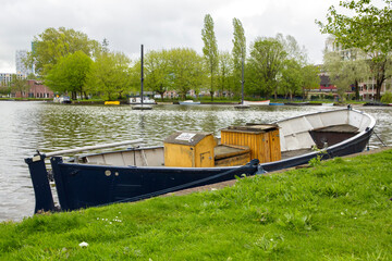 Blue boat anchored along a canal in Amsterdam, Netherlands.