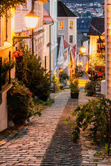 A romantic evening scene of a narrow cobblestone street in Bergen, Norway