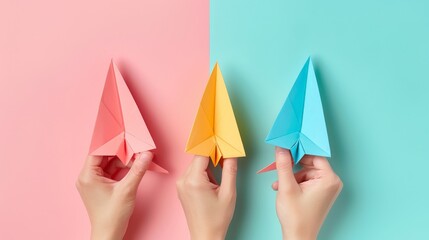 An isolated background with three different colored paper airplanes in a woman's hands.
