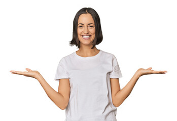 Young Caucasian woman with short hair makes scale with arms, feels happy and confident.