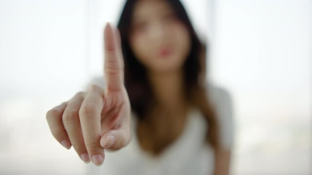 Portrait of young asian woman shaking finger in negation, person saying no with hand.