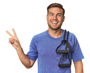 Athlete with resistance band joyful and carefree showing a peace symbol with fingers.