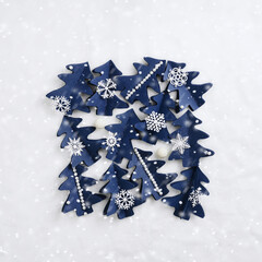 Winter Holidays decoration, Christmas trees of blue craft paper, Christmas New Year minimal style pattern, greetings card. Handcraft firs decorated snowflakes, pearls on white fur. Top view